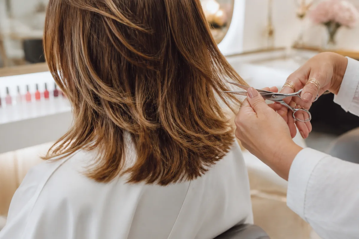 Détail d’une coupe dégradée sur cheveux mi-longs, mèches travaillées aux ciseaux